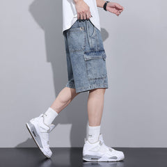 A person wearing a white t-shirt, mens denim shorts with an elastic waist, white crew socks, and white sneakers stands in profile against a plain gray background.