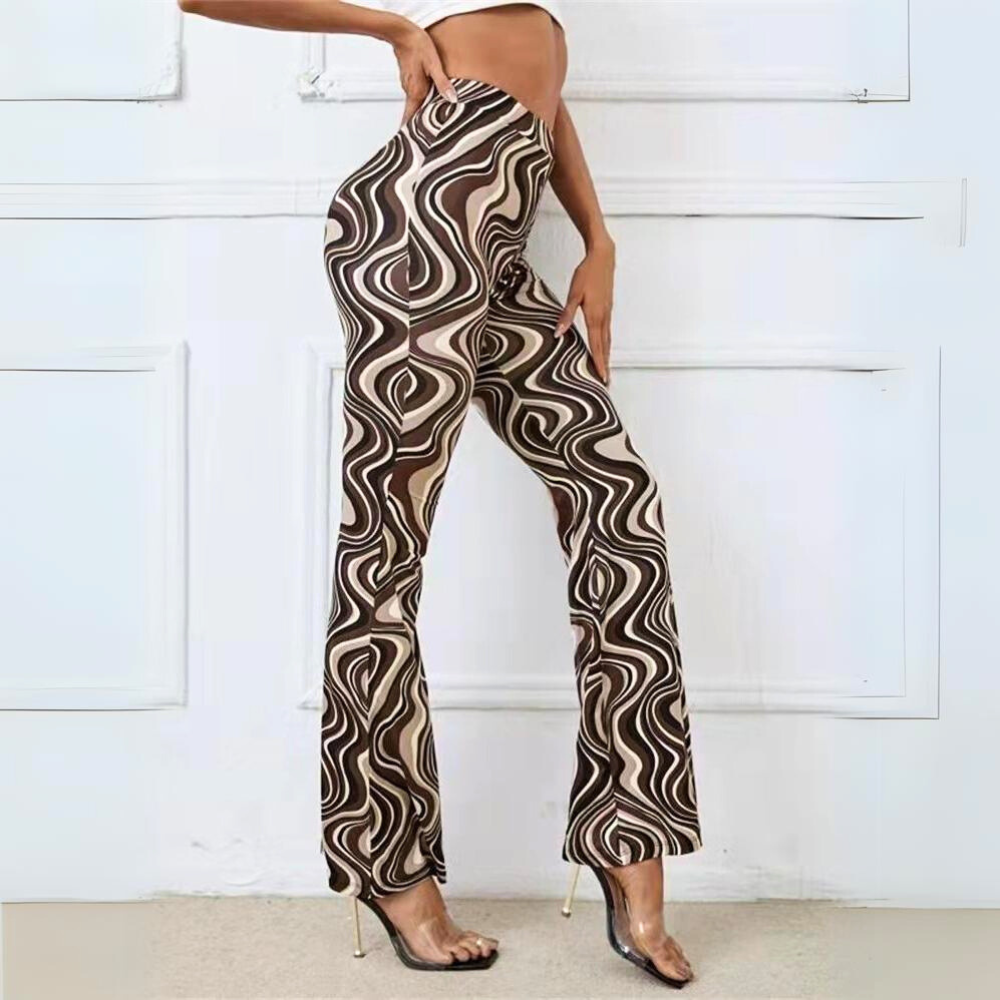 A person poses sideways, wearing trendy statement pants with high-waisted, brown and beige swirl patterns and clear high-heeled shoes. The cropped top reveals their midriff. The background features a white wall with decorative panels.