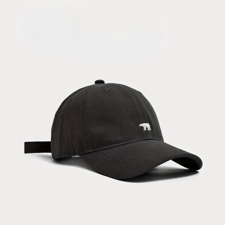 A black wide brim cap made from premium cotton, featuring a small white bear logo embroidered on the front, photographed against a plain white background for added sun protection.