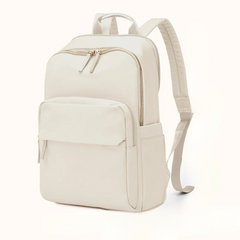 A minimalist, light beige, water-resistant backpack with gold zippers, a large front pocket, side pockets, adjustable padded shoulder straps, and a dedicated laptop compartment, displayed against a plain white background.
