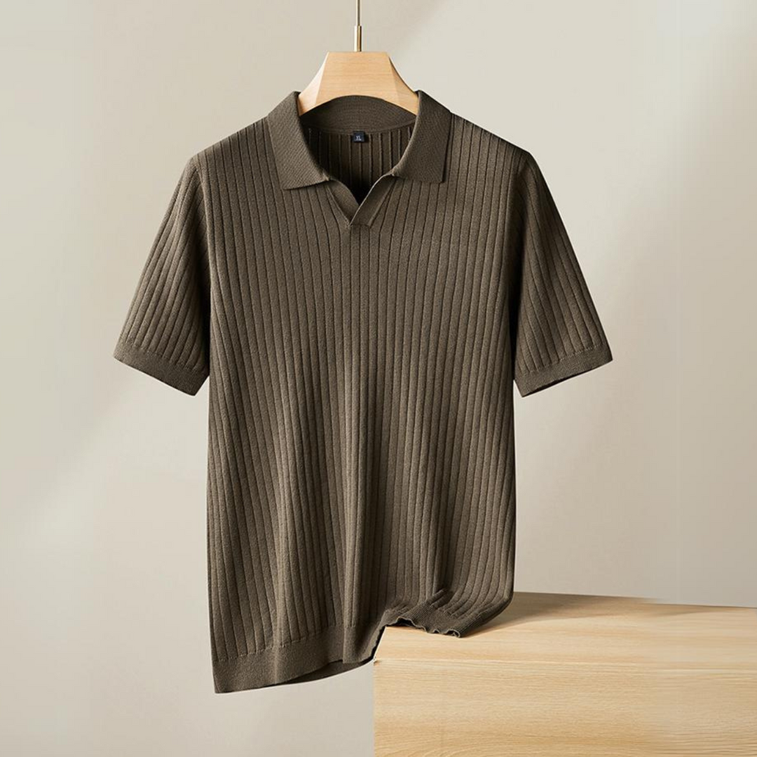 A short-sleeved, ribbed knit polo in brown hangs on a wooden hanger against a plain, light background, with the bottom edge resting on a wooden surface. Perfect for the urban professional seeking effortless style.