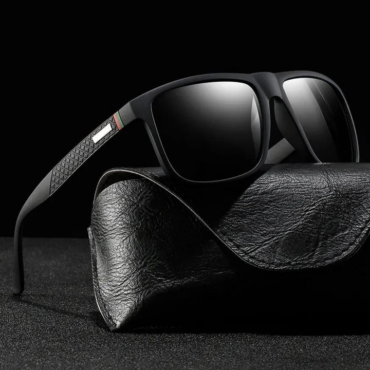 A pair of stylish sunglasses with dark lenses rests on a textured black leather case against a black background. The temples have a decorative pattern near the hinges, and the UV400 sunglasses offer both elegance and protection.
