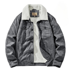 A gray suede jacket with a white, fluffy Sherpa lining and collar, front button closures, and two chest pockets with flaps. The jacket offers a structured fit and is laid flat on a white background.