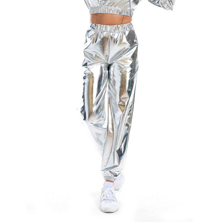 A person wearing shiny silver metallic pants with an elastic high waist and white shoes is walking, their upper body partially out of frame against a white background.