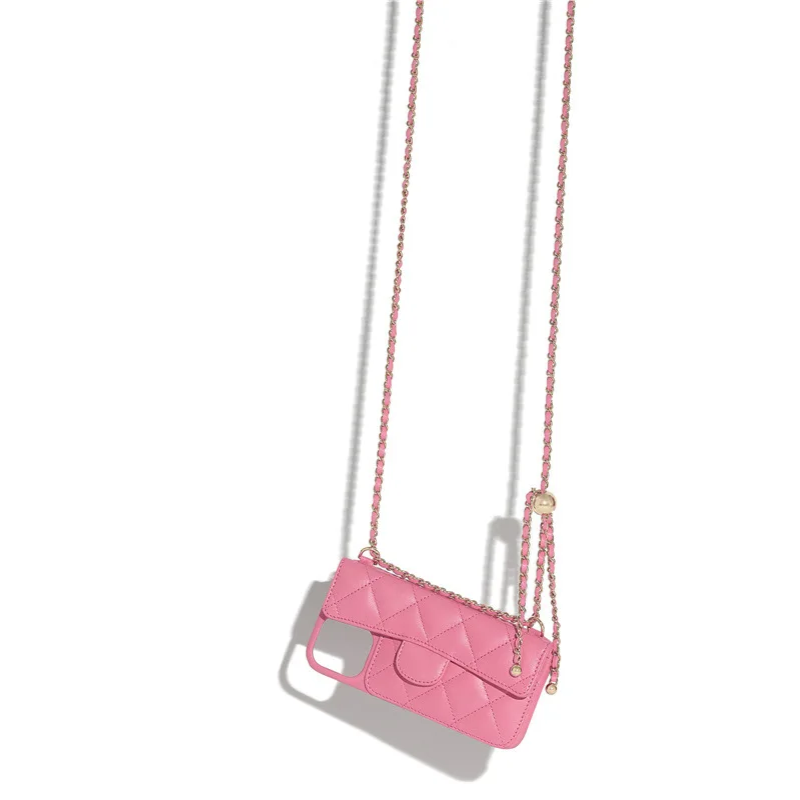A small pink quilted phone case with a stylish chain strap, designed to be worn like a crossbody bag, is photographed against a white background with a shadow.