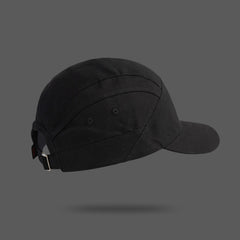 A black unisex cap shown from the back and side, featuring a metal buckle and adjustable strap, set against a plain gray background with a subtle shadow underneath.