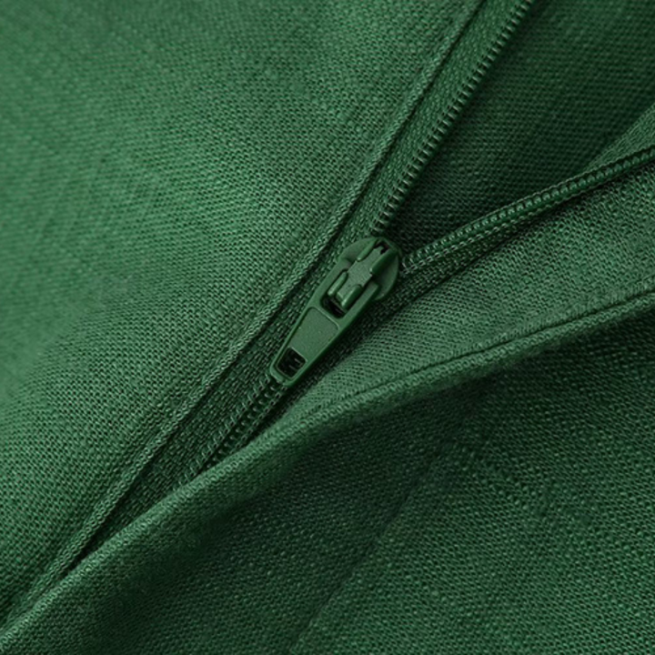 Close-up of a green zipper partially unzipped on green fabric, capturing the texture and details—perfect for adding flair to wide-leg trousers or boho chic pants.
