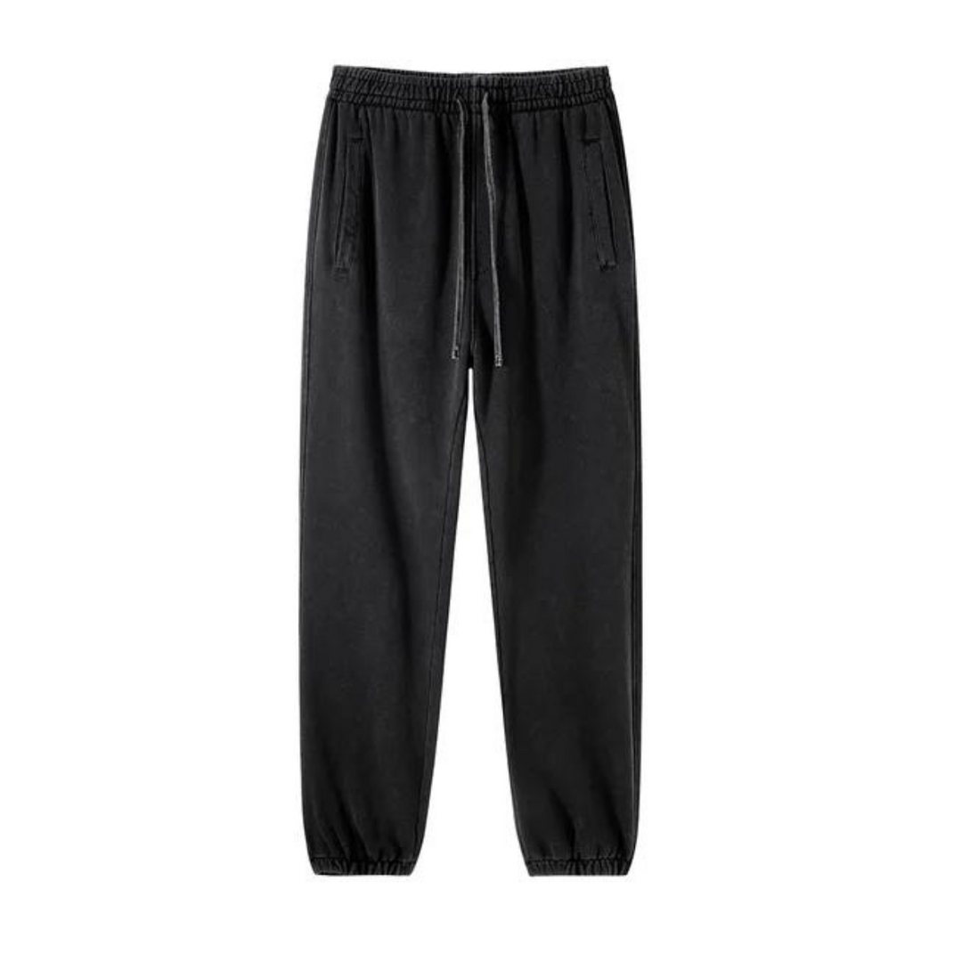 Black jogger-style sweatpants with an elastic waistband, drawstring, deep pockets, and tapered cuffs at the ankles, displayed on a white background.