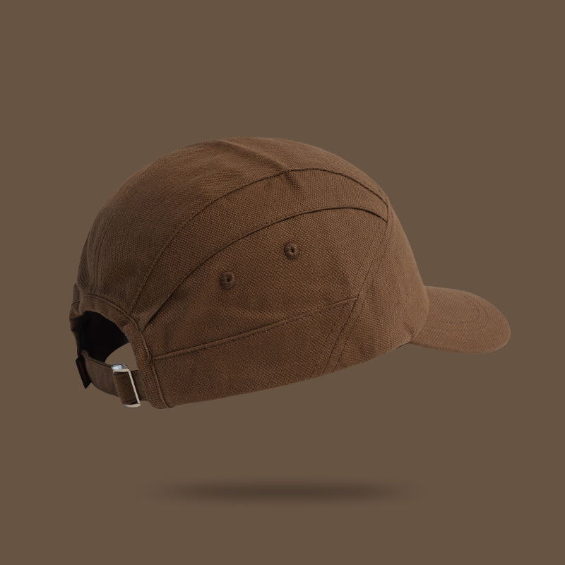 A brown, Japanese-style peaked cap with a metal buckle and an adjustable strap for the perfect fit.
