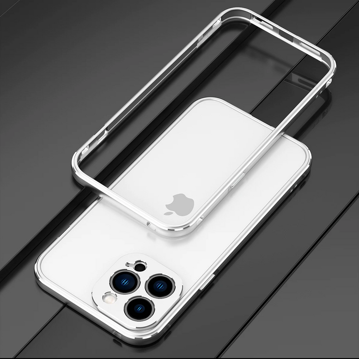 A white smartphone with a triple camera setup lies on a black surface. Above it, a durable phone case with transparent back and metallic edges highlights the phone’s camera features while offering drop protection.