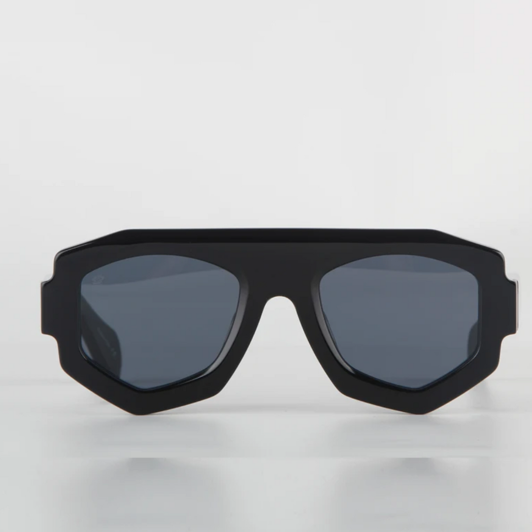 A pair of black geometric sunglasses with dark tinted lenses features a bold, angular acetate frame and offers UV400 protection, displayed against a plain white background.