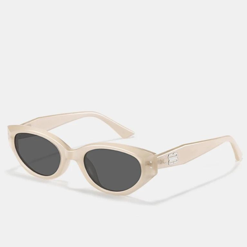 Cream-colored cat-eye sunglasses with dark lenses and a thick, translucent acetate frame. The left arm features a small, subtle raised DG logo near the hinge. Stylish and modern, these shades offer reliable UV400 protection. Displayed on a plain white background.
