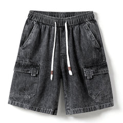 A pair of mens denim shorts in black with an elastic waist, white drawstring, side pockets, and flap pockets on each leg—laid flat on a white background.