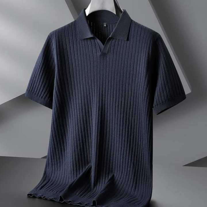 A dark navy blue ribbed knit polo with short sleeves and a vertical stripe texture hangs on a black hanger against a modern, geometric gray background—perfect for the urban professional.