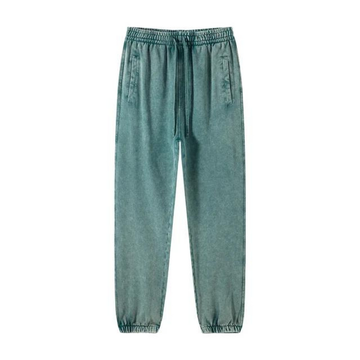 Teal green jogger pants with an elastic waistband, drawstring, deep pockets, and tapered cuffs at the ankles, displayed on a white background.