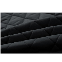 Close-up of black quilted fabric with a diamond stitch pattern, showing soft, padded texture and slightly raised seams—ideal for a slim-fit jacket with cozy cotton insulation.