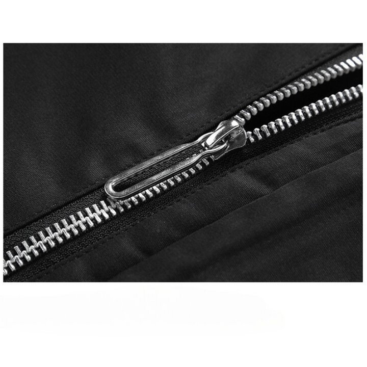 Close-up view of a partially unzipped silver zipper on black fabric, revealing the detailed zipper teeth and pull tab of this windproof jacket.