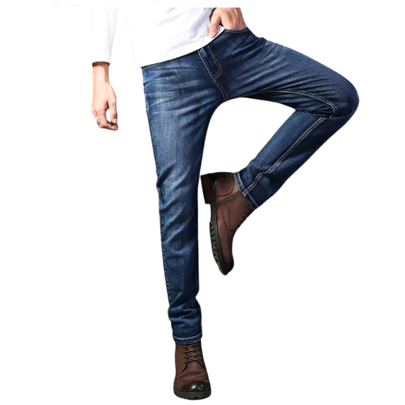 A person wearing slim-fit jeans crafted from durable fabric, brown lace-up boots, and a white long-sleeve shirt stands with one leg bent and hand in pocket on a white background.