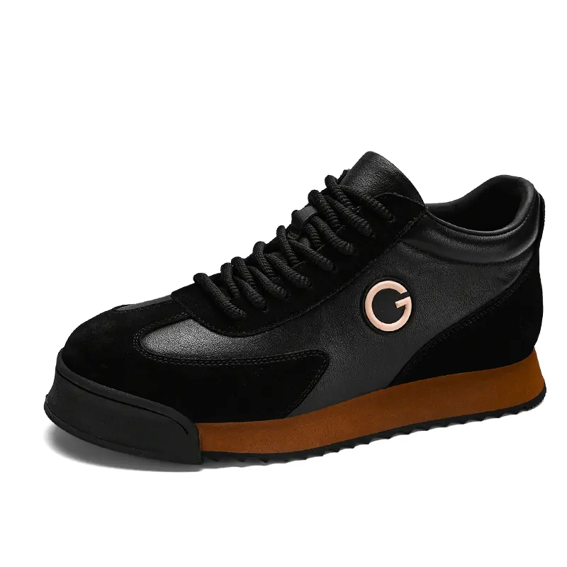 Black sneaker with a brown sole, featuring a rounded toe, black laces, and a gold G logo on the side. These sleek sneakers combine luxe leather suede for an urban professional look with modern style and textured appeal.