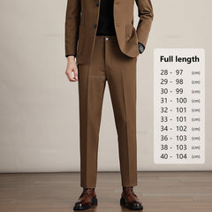 A man in a brown suit stands on a wood floor against a beige background. Next to him, a size chart for Mens Slim Casual Trousers in premium fabric shows pant lengths from 97 cm to 104 cm for sizes 28 to 40.