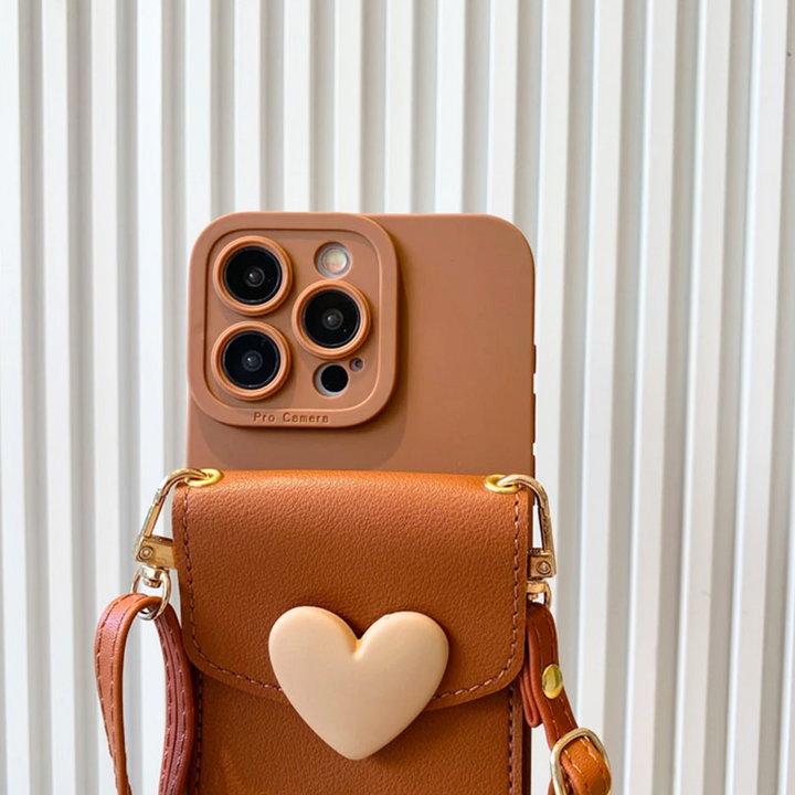 A brown smartphone with a chic phone case and camera cover rests inside a small brown leather bag with a heart-shaped decoration, set against a white vertical striped background.