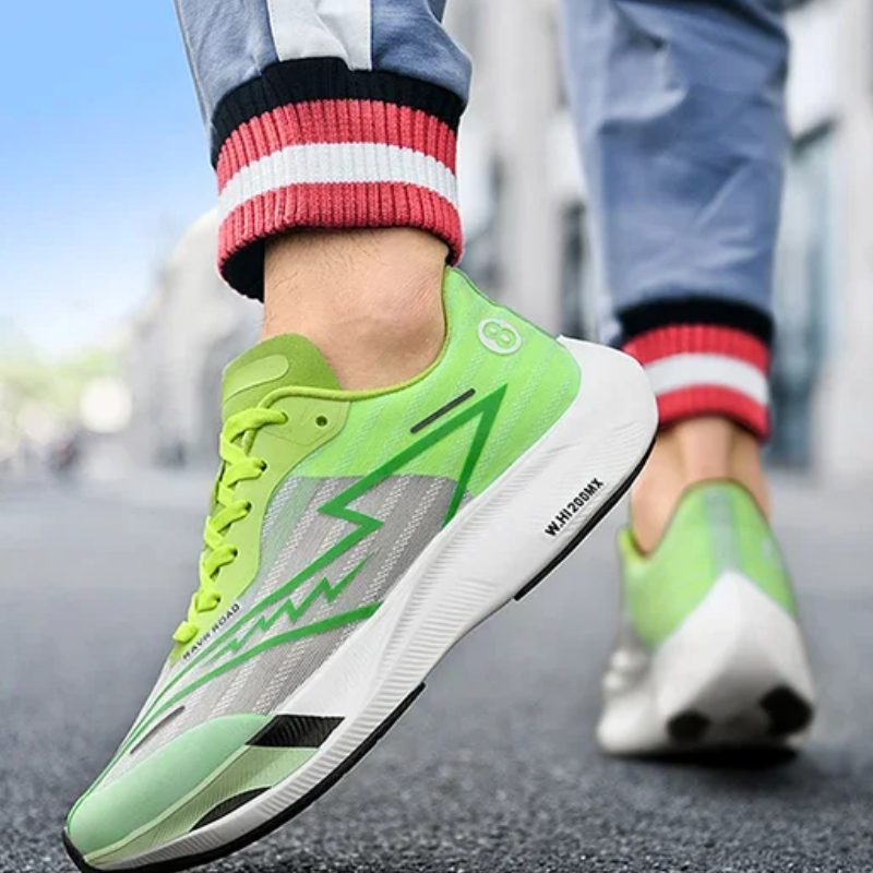 A close-up of a person wearing neon green athletic running shoes with white shock-absorbing soles and lightning bolt designs, standing on a city street. The person is dressed in blue pants with red and white striped cuffs.
