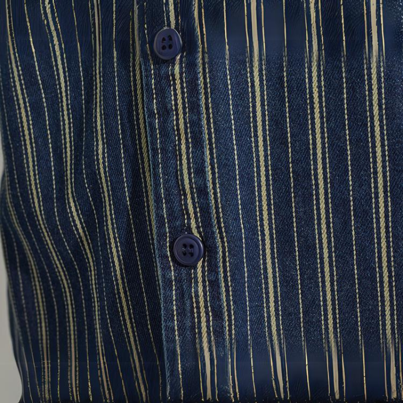 Close-up of a relaxed-fit button-down in dark blue with thin vertical white and beige stripes, featuring two dark blue buttons along the placket.