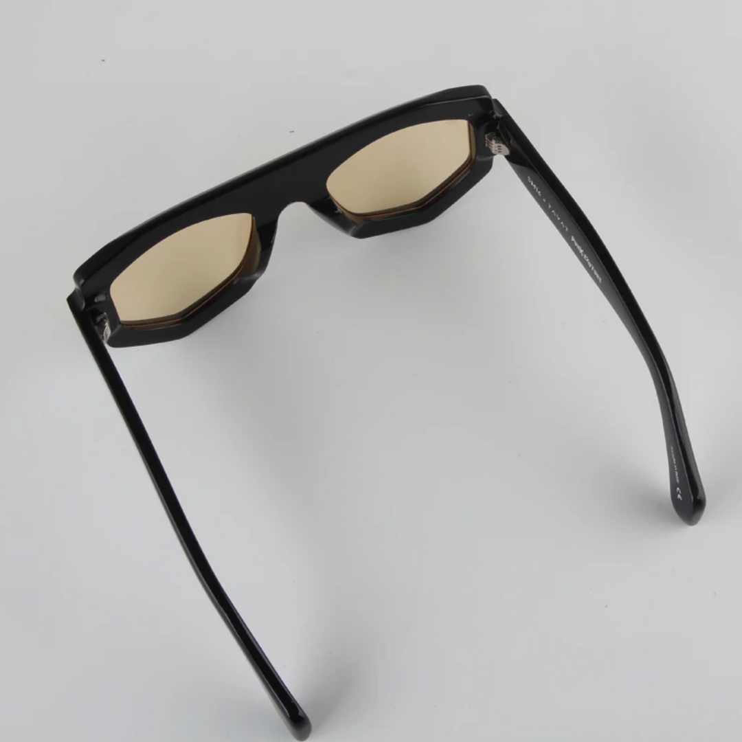 A pair of black acetate, geometric frame glasses with slightly tinted lenses, shown from an angled top view on a plain white background.