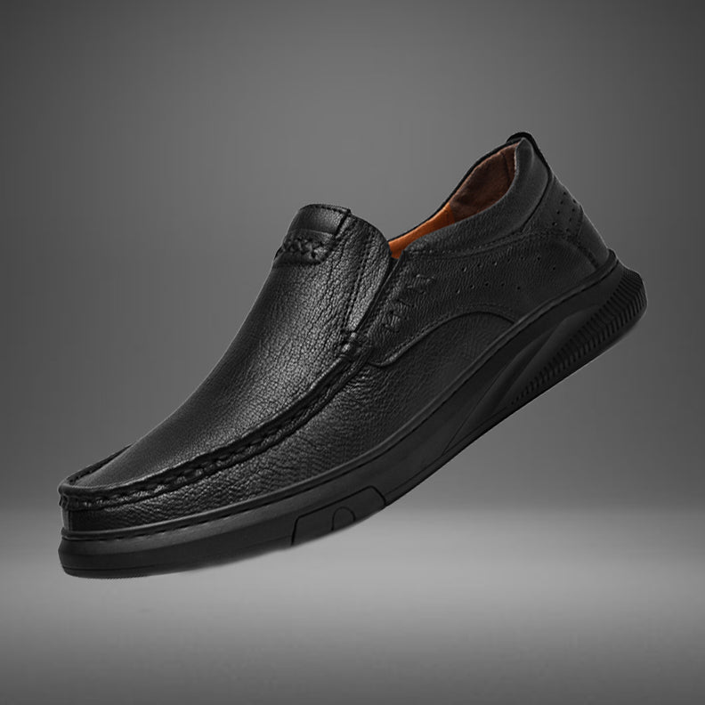 A single men's cowhide leather slip-on loafer with a soft, textured sole and visible stitching is displayed on a grey gradient background.