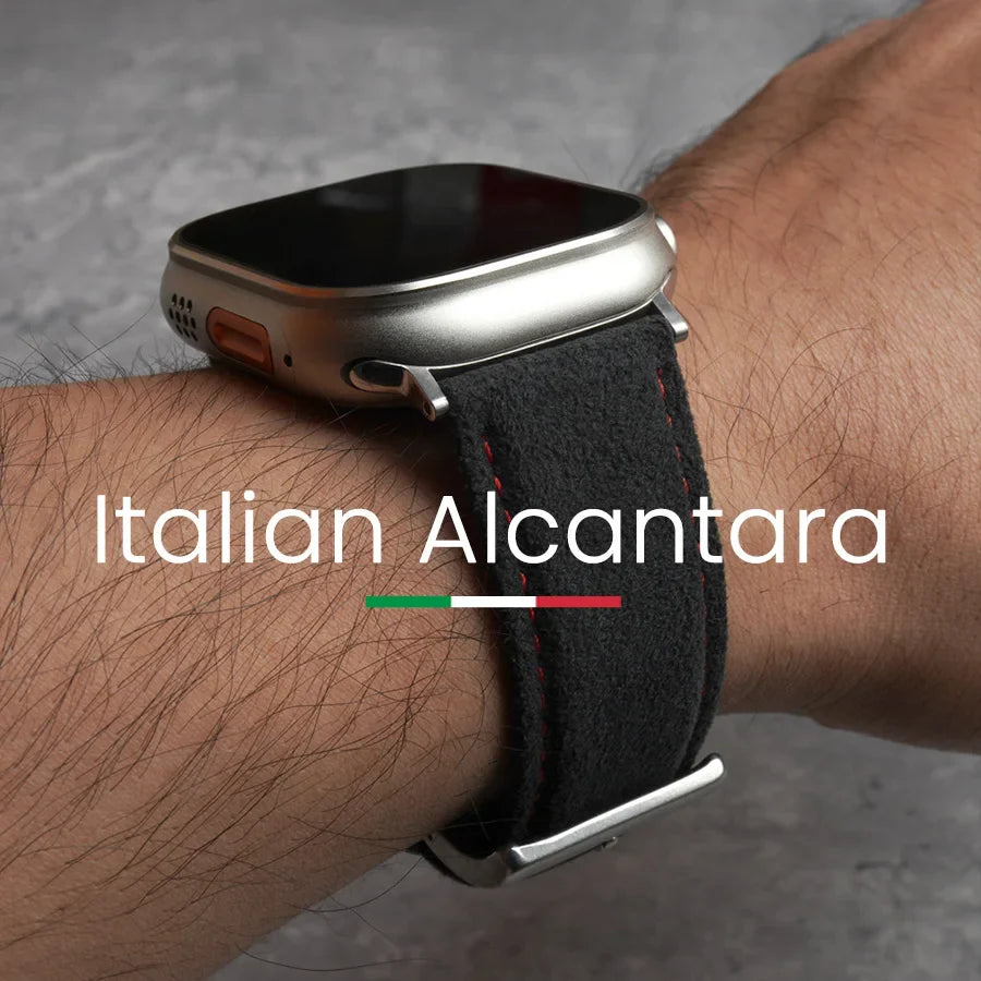 A close-up of a person’s wrist wearing a smartwatch with a black Italian Alcantara band and a stainless steel buckle. Text over the image reads Italian Alcantara with a green, white, and red stripe below.