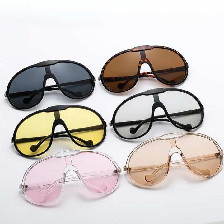 Six pairs of oversized sunglasses with UV400 protection—black, brown, white, yellow, pink, and clear—are arranged in two rows on a white surface, perfect for outdoor activities in any style.