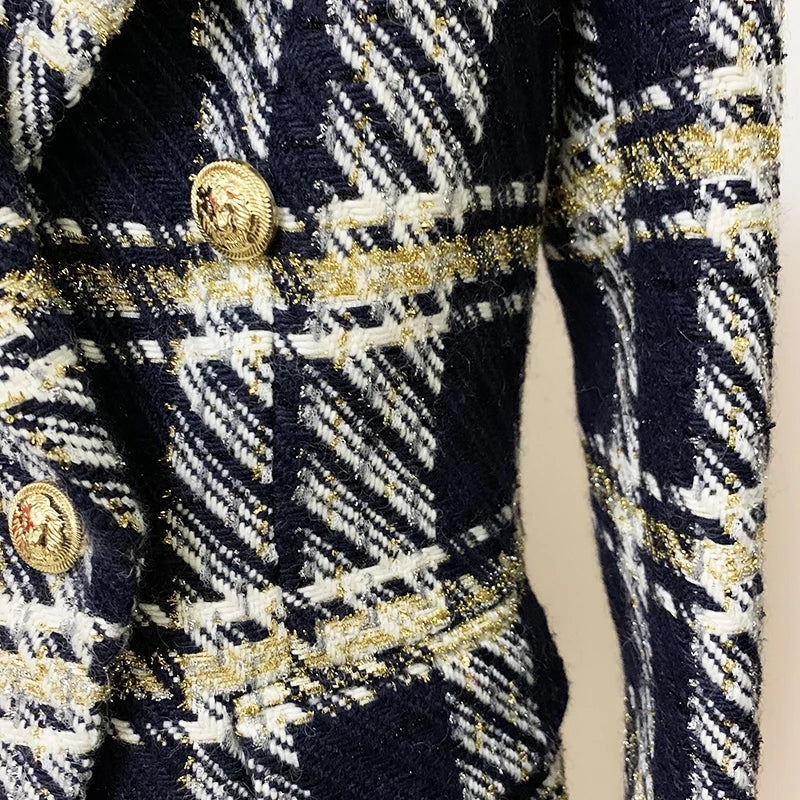 Close-up of a navy blue, white, and gold plaid wool tweed designer jacket featuring shiny gold buttons and a structured lapel.