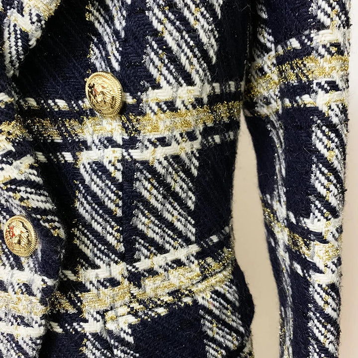 Close-up of a navy blue, white, and gold plaid wool tweed designer jacket featuring shiny gold buttons and a structured lapel.