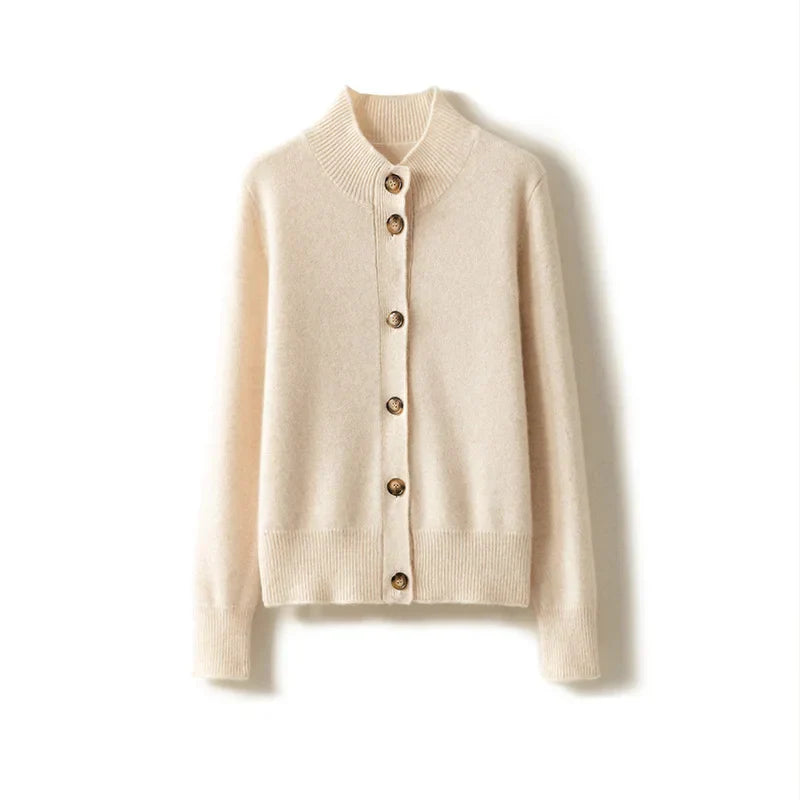 An ultra soft, cream-colored cashmere cardigan with long sleeves, brown buttons, and a ribbed collar, cuffs, and hem, displayed on a white background.
