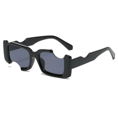 Black rectangular avant-garde sunglasses with thick frames and eyebrow-shaped cutouts above the lenses offer UV400 protection, resting on a white background.