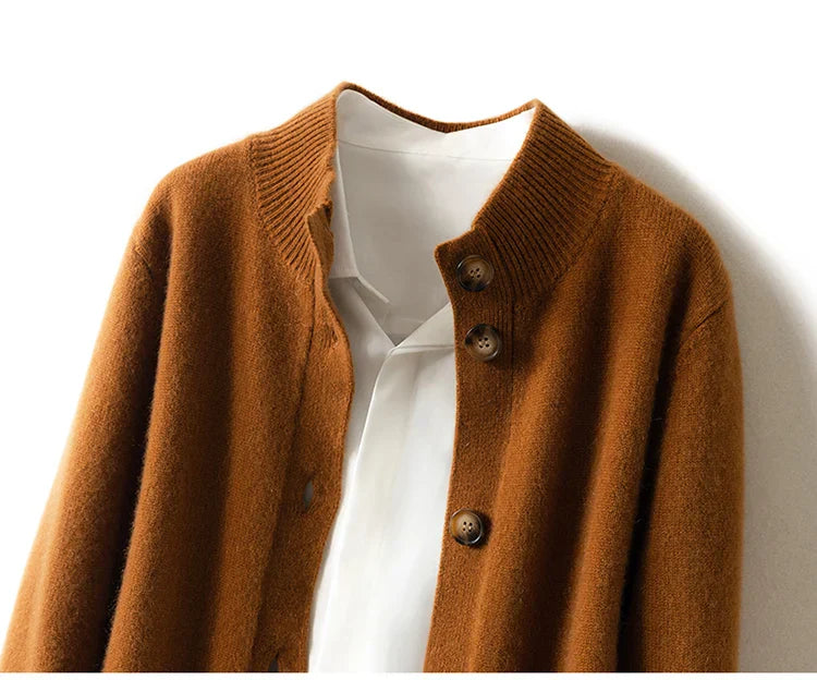 A brown ultra soft cashmere cardigan with a ribbed collar is layered over a white collared shirt, both hanging neatly against a white background.