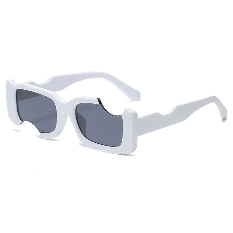 Rectangular sunglasses with thick, glossy white geometric frames and dark lenses. The frames feature a unique wavy cutout design on the top edge above each lens and along the temples for a bold, street style look.
