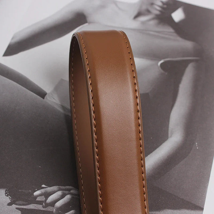 A close-up of a genuine leather strap with visible stitching, placed on top of a black and white photo of a person wearing a swimsuit.