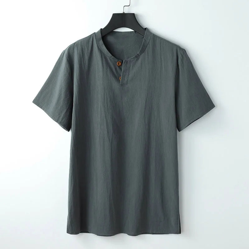 A short-sleeved, dark gray Japanese linen shirt with a round collar and two brown buttons at the neckline, displayed on a black hanger against a plain white background.