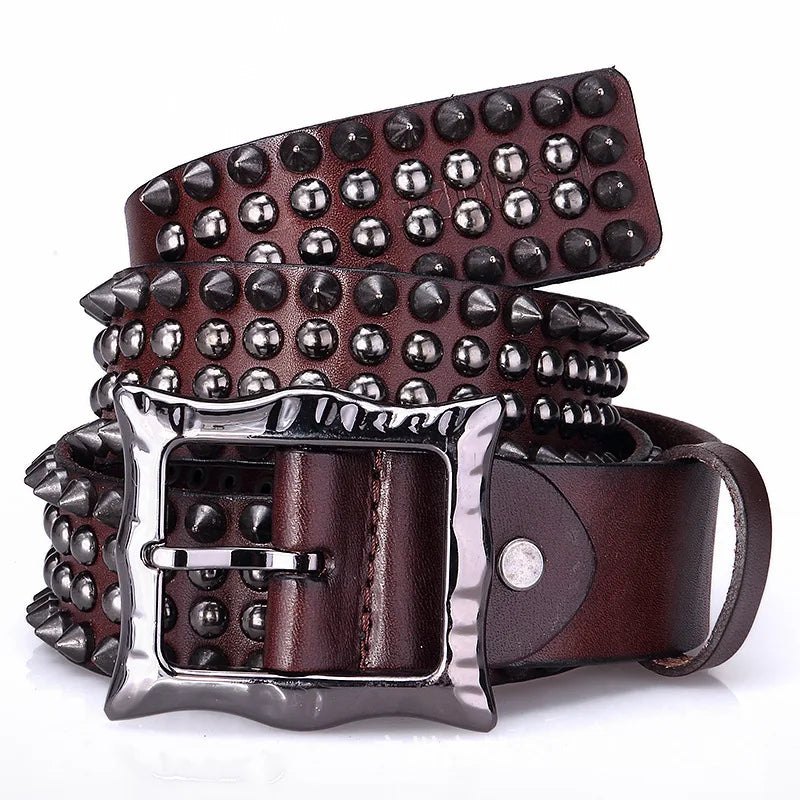 A brown leather belt with studded detailing and a shiny silver, adjustable buckle, decorated with rows of metallic studs and spikes along its length, coiled neatly in a spiral.
