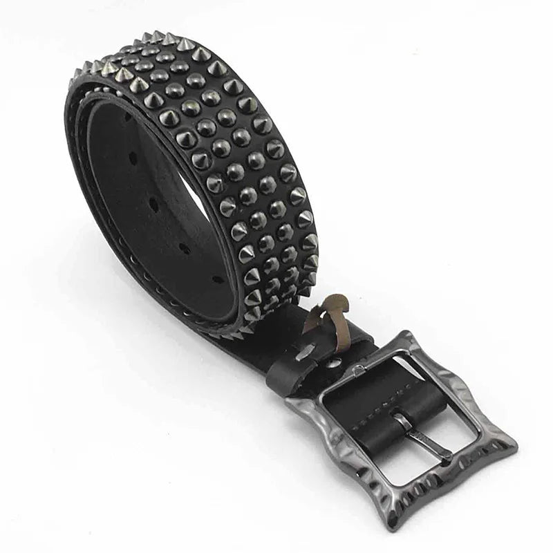 A rolled-up black leather belt featuring multiple rows of metal spikes, studded detailing, and a metal buckle with a hammered texture.