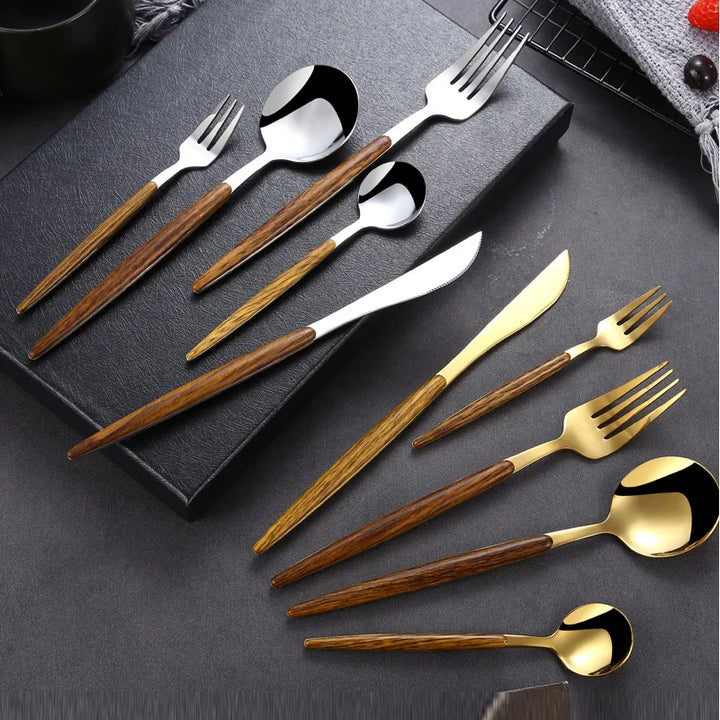 A stainless steel cutlery set featuring forks, spoons, and knives with wooden handles and metallic heads in silver and gold, neatly arranged on a black surface.