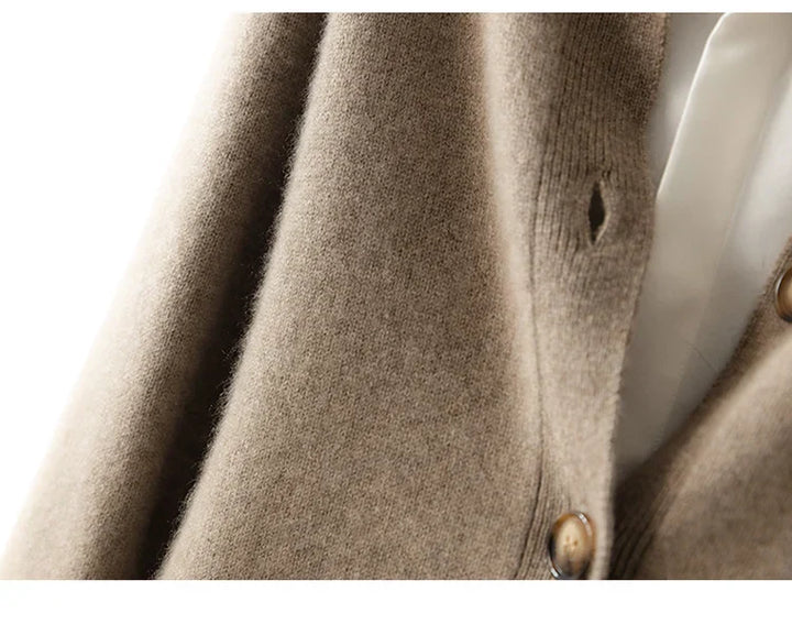 Close-up of an ultra soft, brown cashmere cardigan over a white shirt, highlighting the fuzzy texture of 100% wool cashmere fabric and part of a button.