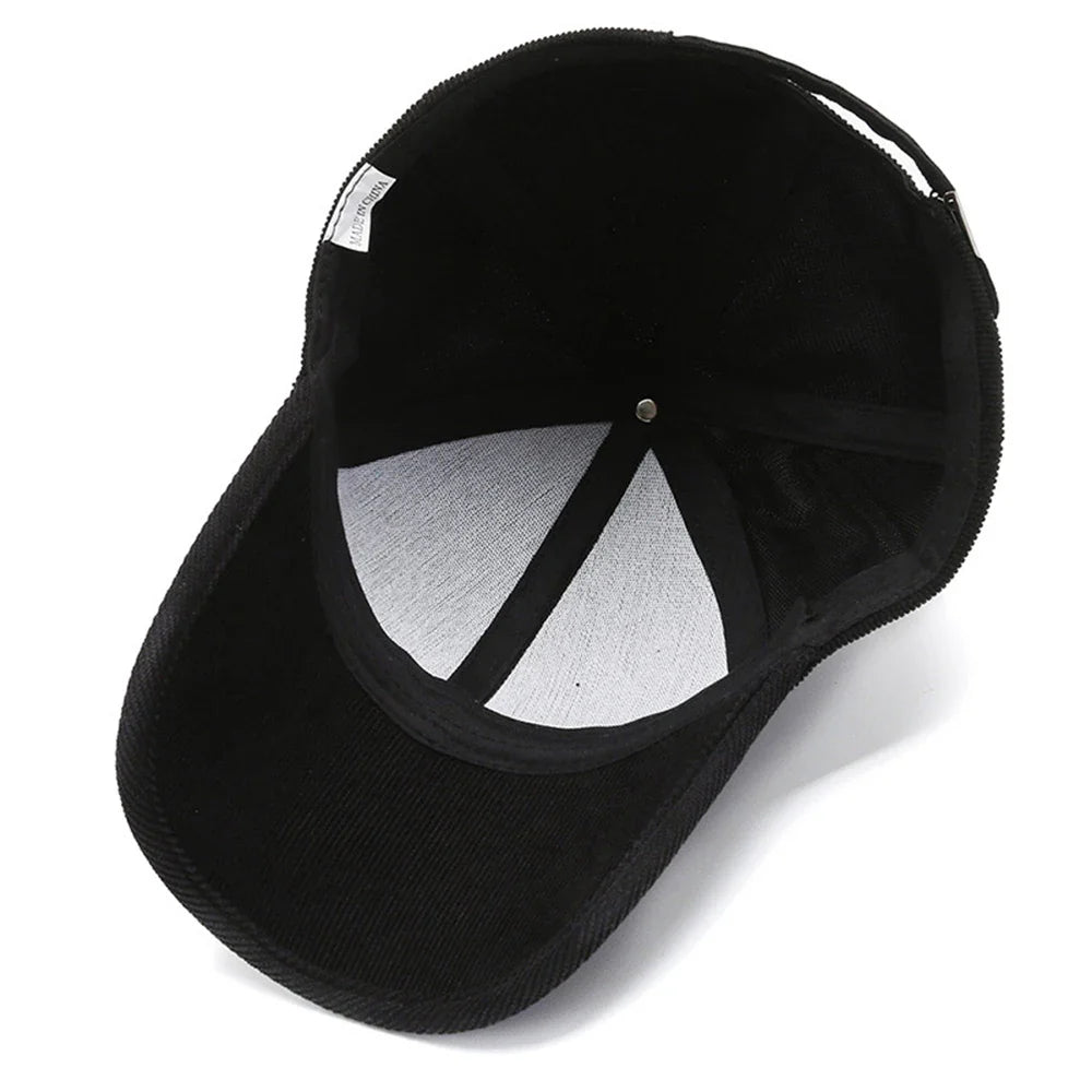 A black cord hat shown from above, highlighting the inside. The white inner lining and black stitching radiate from the metal button at the crown, and the curved brim is facing forward for classic retro style.