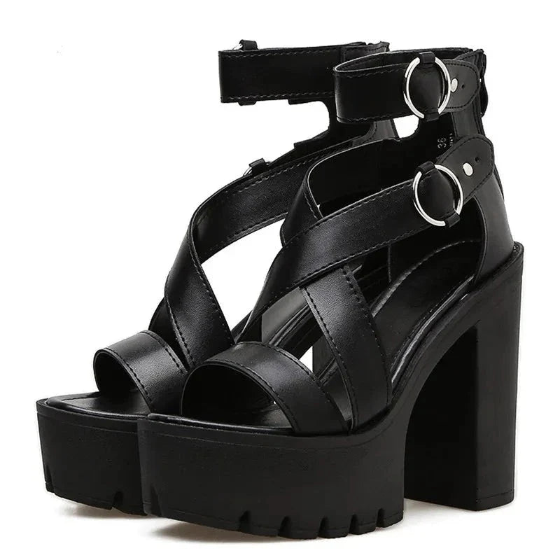A pair of black high heel sandals with thick block heels, open toe design, crisscross straps, and silver buckle ankle straps shown against a white background.