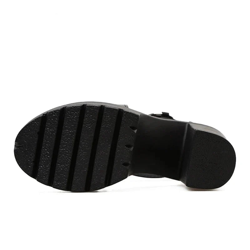 The image shows the bottom view of a black platform women sandal with a chunky heel and a textured sole featuring four wide horizontal grooves.