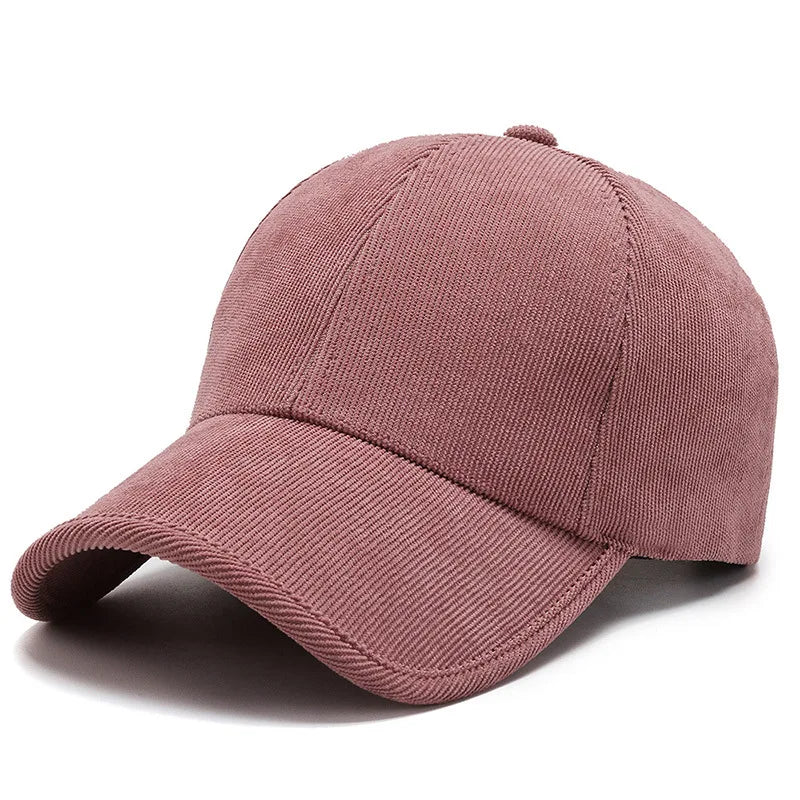 A plain mauve-colored corduroy hat with a curved brim, shown at an angle on a white background.