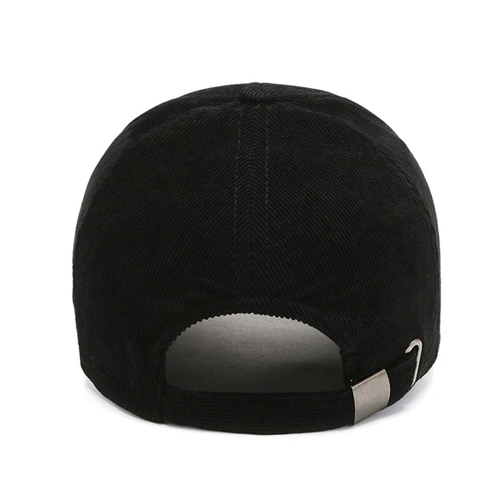 A black corduroy baseball cap seen from the back, featuring an adjustable strap with a metal buckle—blending modern comfort with retro hats style.