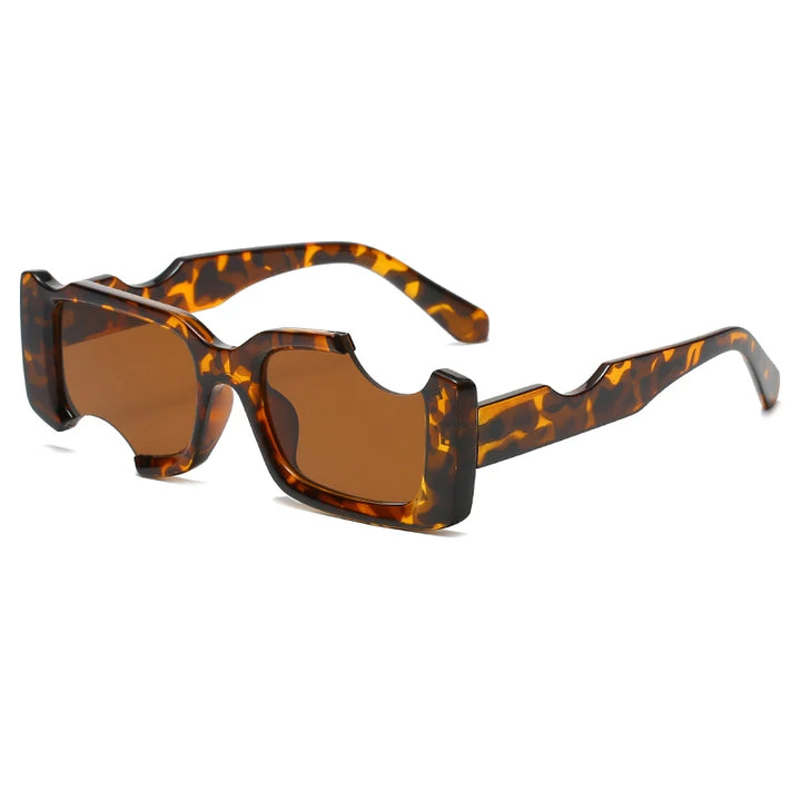 A pair of rectangular sunglasses with tortoiseshell-patterned geometric frames and brown-tinted lenses, featuring a unique, chunky, and angular design with cut-out details above the lenses—perfect for bold street style.