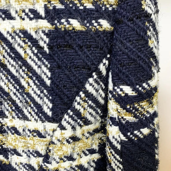 Close-up of a plaid wool tweed fabric with navy blue, white, and gold threads. The weave is thick and detailed, perfect for a designer jacket, with visible gold metallic accents adding luxe appeal to the pattern.
